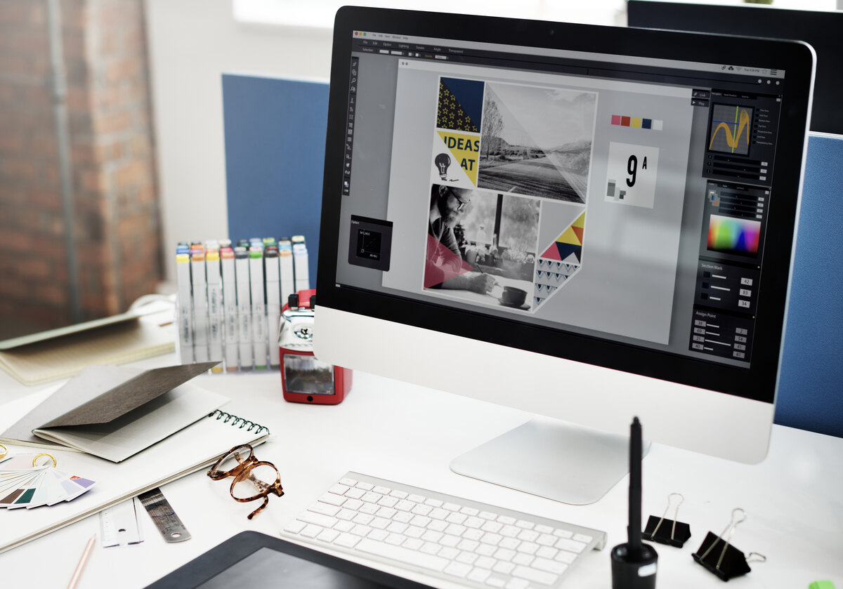 Workspace de diseño con Photoshop, monitores y muestras de etiquetas