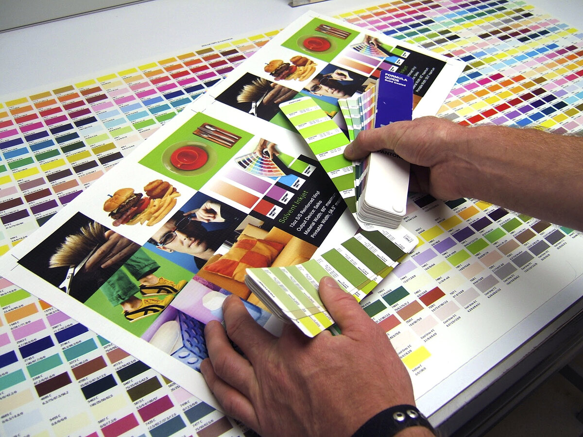 Pruebas de color sobre escritorio con muestras y paletas Pantone